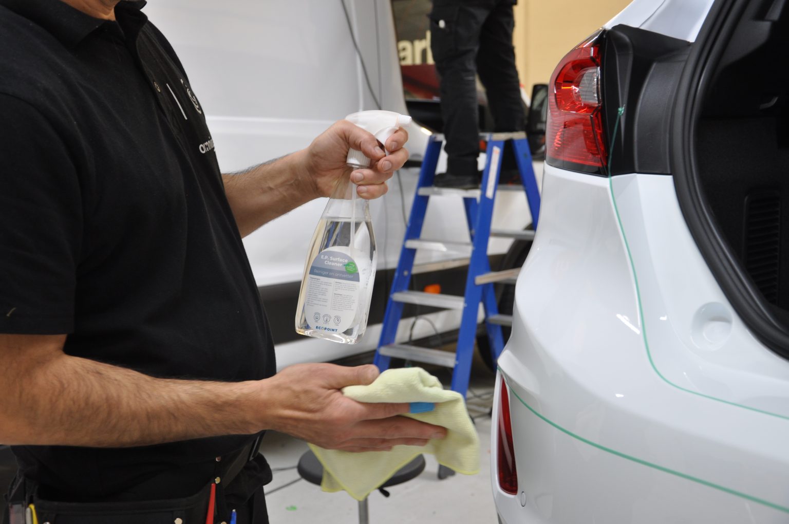 Een monteur met een fles E.P. Surface Cleaner